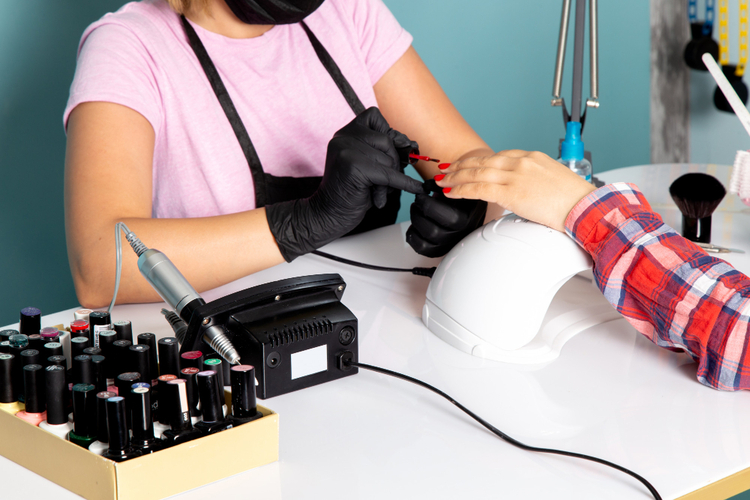 Werkende vrouw bij nagelstudio